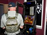 Funkcjonariusz Służby Celno-Skarbowej stoi przy automacie do gier hazardowych