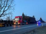 Na drodze krajowej stoi pojazd przewożący elementy wagonów kolejowych. Za pojazdem samochód służbowy Służby Celno-Skarbowej.